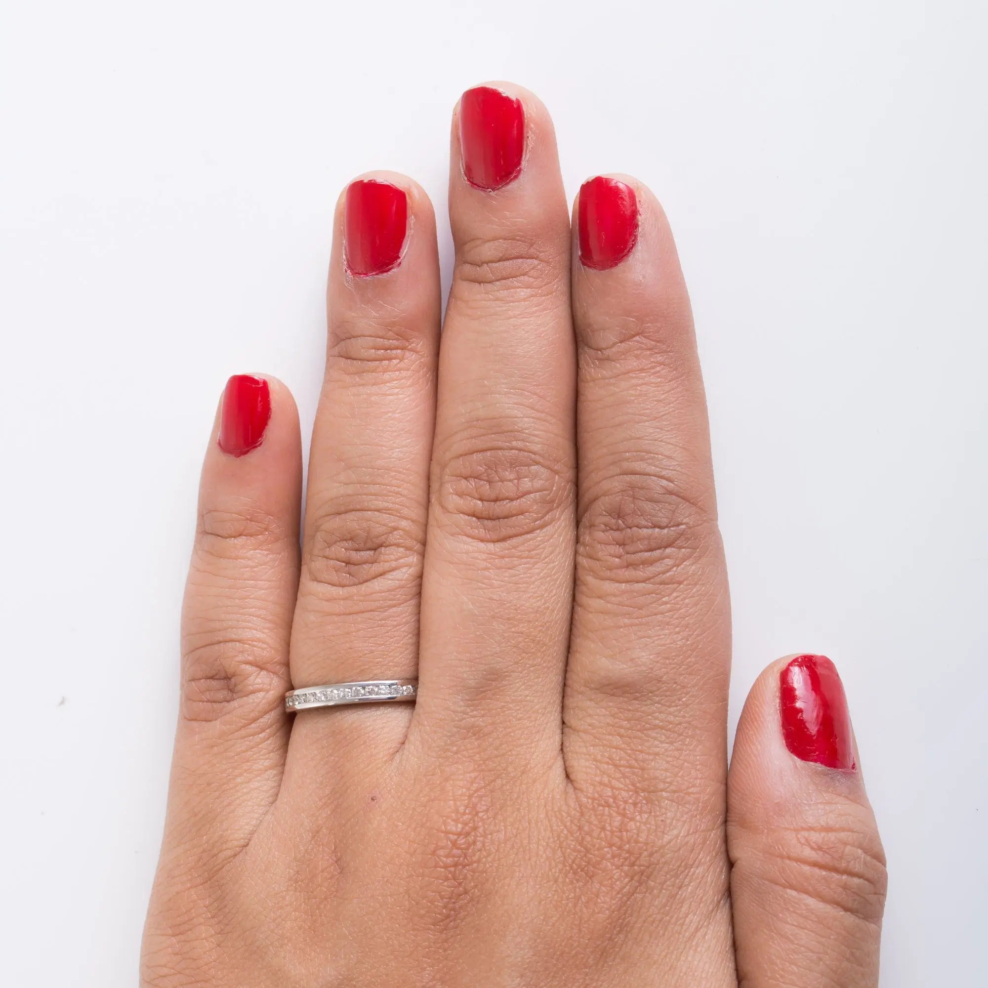 Finger shot of half eternity platinum ring with diamonds showing how the platinum ring looks when worn on the finger of a woman.